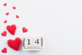 Valentines day and love concept. Handmade red heart and February 14 text on wooden block on white wooden background