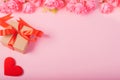 Valentines day and love concept. One small gift box with red heart and flowers on pink background Royalty Free Stock Photo