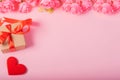 Valentines day and love concept. One small gift box with red heart and flowers on pink background Royalty Free Stock Photo