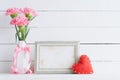 Valentines day and love concept. Pink carnation flower in vase with old vintage picture frame and red heart and on white Royalty Free Stock Photo