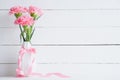 Valentines day and love concept. Pink carnation flower in vase with Wooden letters forming word LOVE written on white background Royalty Free Stock Photo