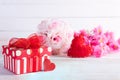 Valentines day and love concept. Pink gift box with handmade red heart and flowers on wooden block on white wooden background Royalty Free Stock Photo