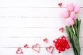 Valentines day and love concept. Pink paper hearts with red gift box and tulips with ribbon Royalty Free Stock Photo