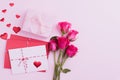 Valentines day and love concept. Pink roses, gift box with red heart and red pink letter cover on pink background Royalty Free Stock Photo