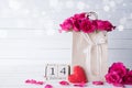 Valentines day and love concept. Pink roses in paper bag with February 14 text on wooden block calendar on white wooden background Royalty Free Stock Photo