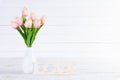Valentines day and love concept. Pink tulips in vase with Wooden letters forming word LOVE written on white wooden background Royalty Free Stock Photo