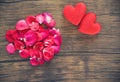 Valentines day love heart concept / Pile of roses petals with red heart decorated on wooden table Royalty Free Stock Photo