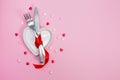 Valentines day meal background with red ribbon, hearts, fork, knife, white plate and napkin. Romantic holiday table Royalty Free Stock Photo