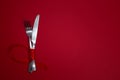 Valentines day meal background with red ribbon, hearts, fork, knife, white plate and napkin. Romantic holiday table Royalty Free Stock Photo