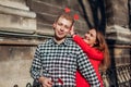 Valentines day photo booth props. Woman hiding heart shaped props in boyfriend`s hair. Couple in love having fun Royalty Free Stock Photo