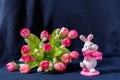 Valentines day pink bunny souvenir with rose bouquet on black background