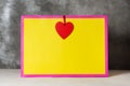 Valentines day present gift bag in bright colors pink and yellow with red heart-shaped tag Royalty Free Stock Photo