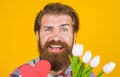 Valentines day presents. Bearded man with heart and bouquet of flowers. Gift for holiday. Royalty Free Stock Photo