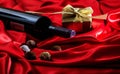 Valentines day. Red wine bottle, chocolates and a gift on red satin