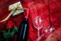 Valentines day. Red wine bottle, glasses and a gift on red textile Royalty Free Stock Photo