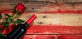 Valentines day. Red wine bottle and red rose on wooden background Royalty Free Stock Photo
