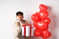 Valentines day and romance concept. Romantic modern man holding special gift for lover and sending air kiss at camera Royalty Free Stock Photo