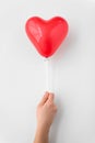 Close up of hand holding red heart shaped balloon Royalty Free Stock Photo