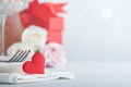 Valentines Day or Romantic dinner concept. Romantic table setting, silverware,  wine glasses, gift box, roses and symbol of love r Royalty Free Stock Photo