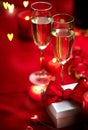 Valentines Day romantic dinner. Date. Champagne, candles and gift box over holiday red background