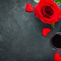 Valentines day or romantic meeting concept. Red rose and red wine on gray background