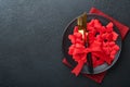 Valentines day romantic table setting. Empty or closeup of a dinner black plate, knife, fork and decorative silk hearts on black b