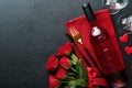 Valentines day romantic table setting. Empty closeup of red roses, wine, candles, dinner black plate, knife, fork and decorative Royalty Free Stock Photo