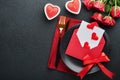 Valentines day romantic table setting. Empty closeup of red roses, wine, candles, dinner black plate, knife, fork and decorative Royalty Free Stock Photo