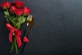 Valentines day romantic table setting. Empty closeup of red roses, wine, candles, dinner black plate, knife, fork and decorative Royalty Free Stock Photo