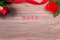 Valentines day sale background, red rose with ribbon and heart on brown wooden table, copy space Royalty Free Stock Photo