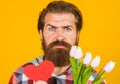 Valentines Day. Serious man with red heart and flowers. Valentine presents with love. Royalty Free Stock Photo