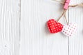 Valentines Day. Sewed pillow hearts row border on red and white clothespins at rustic white wood planks. Happy lovers day card moc Royalty Free Stock Photo