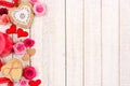 Valentines Day side border of hearts, flowers, gifts and decor on white wood