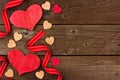 Valentines Day side border of wood hearts and ribbon over rustic wood Royalty Free Stock Photo