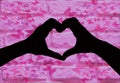 Valentines day, silhouette of two hands making a heart shape together on a pink brick wall with butterfly`s Royalty Free Stock Photo