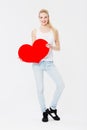 Valentines day specials. Portrait of a smiling girl holding a card board cut out of a heart against a white background. Royalty Free Stock Photo
