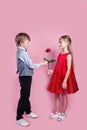 Valentines day surprise. Little boy in love giving cute girl red rose , Royalty Free Stock Photo