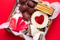 Valentines Day sweets and cookies in wooden box on red background. Chocolate, meringue, marshmallow, linzer cookies, gingerbread. Royalty Free Stock Photo