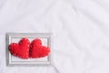 Valentines Day and symbol of love. Two red hearts in picture frame on white fabric background Royalty Free Stock Photo