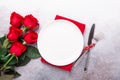 Valentines day table place setting with bouquet of red roses, red hearts on stone background. Top view. Valentine`s card Royalty Free Stock Photo