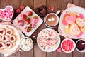 Valentines Day table scene of assorted sweets and cookies, top view over a wood background