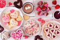 Valentines Day table scene with a selection of sweets and cookies, top view over a white wood background