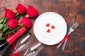 Valentines day table setting empty plate, red roses and champagne glasses on wooden background. Top view. Valentine`s greeting Royalty Free Stock Photo