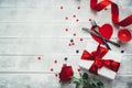 Valentines day table setting with fork, knife, red hearts, ribbon and roses. Royalty Free Stock Photo