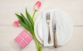 Valentines day table setting with pink tulips and a gift on white wooden background. Top view Royalty Free Stock Photo