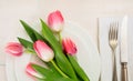 Spring table setting with pink tulips on white wooden background. Top view Royalty Free Stock Photo