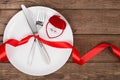 Valentines day table setting with plate, fork, knife, red heart, ring and ribbon. background Royalty Free Stock Photo