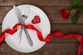 Valentines day table setting with plate, fork, knife, red heart, ring, ribbon and rose. background Royalty Free Stock Photo