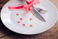 Valentines day table setting with plate, knife, fork, red ribbon Royalty Free Stock Photo