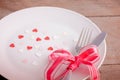 Valentines day table setting with plate, knife, fork, red ribbon Royalty Free Stock Photo